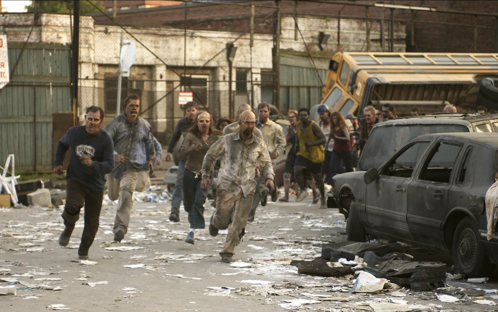 Afbeelding van rennende zombies in een vervallen omgeving.